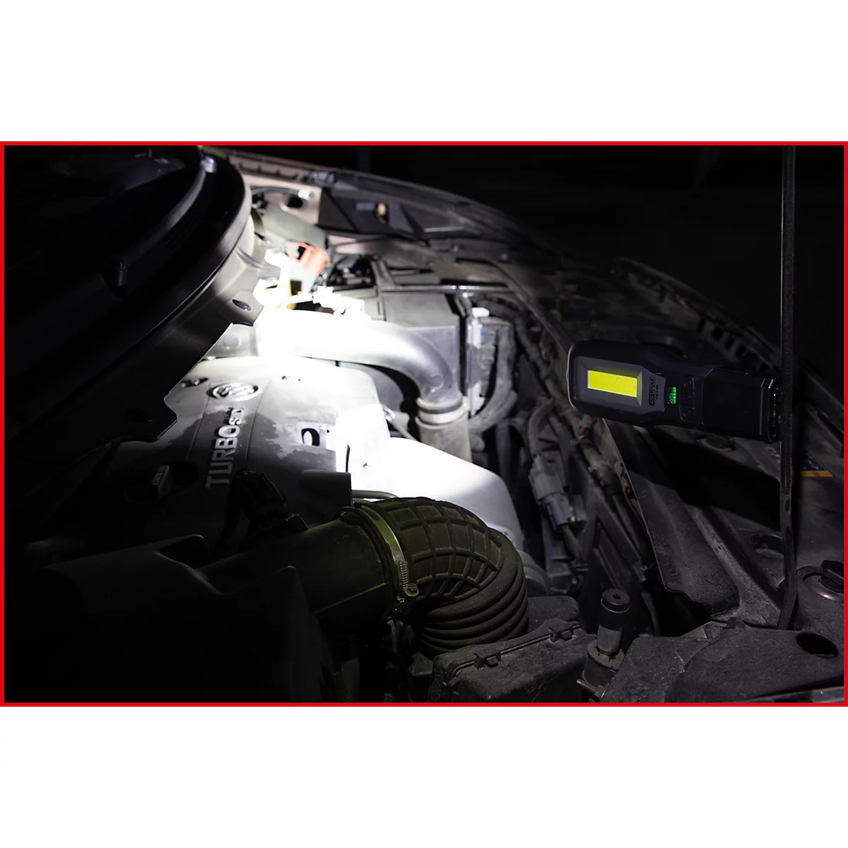 Motorruimte verlicht door een zaklamp, onderdelen van de motor zijn zichtbaar. Het woord Turbo is herkenbaar.